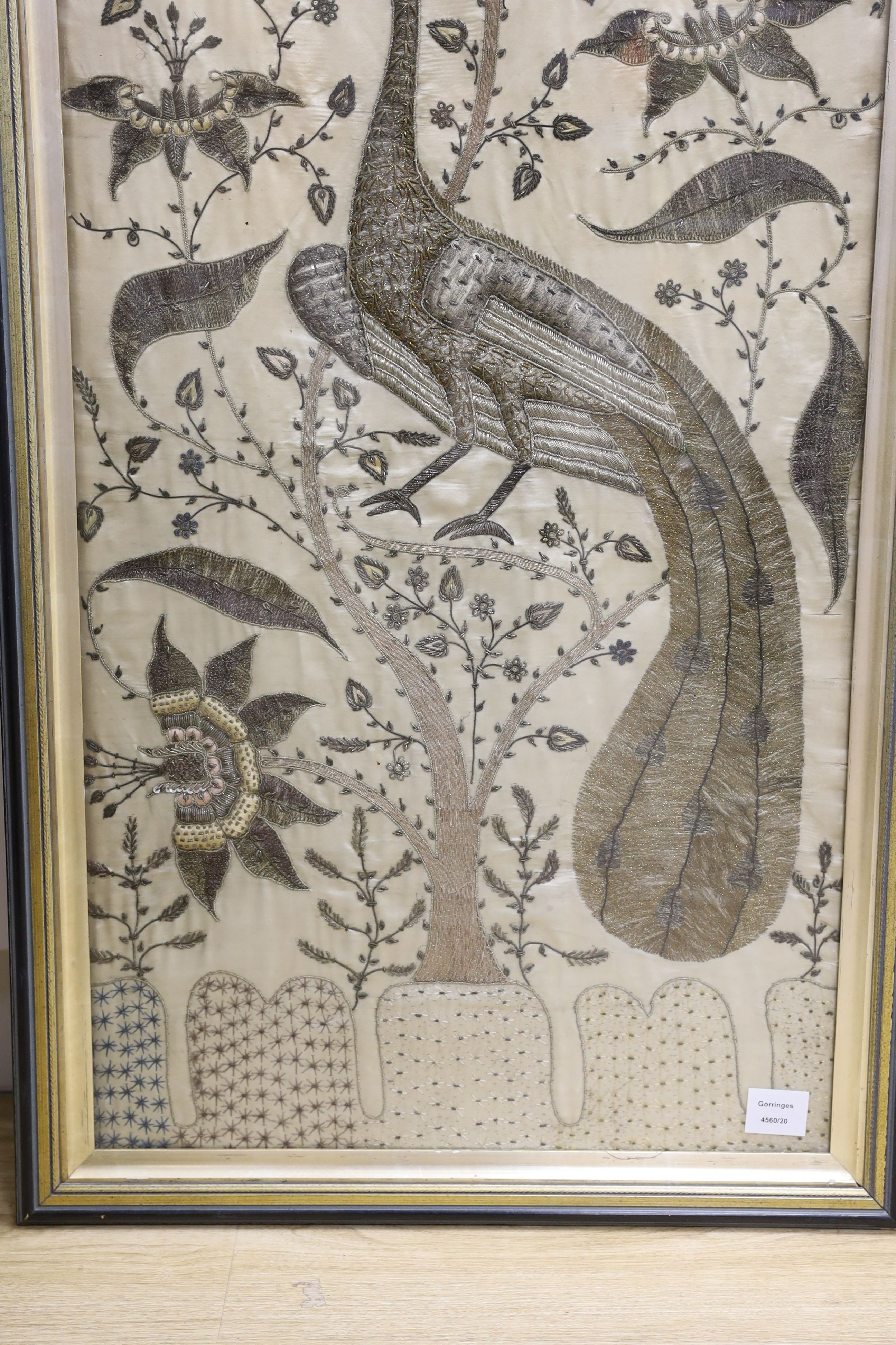 A framed large 19th century Indian embroidered panel decorated with a peacock and flowers 108x49cm